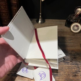 Blank notebook. Leather-bound back. ("Merci Louis")